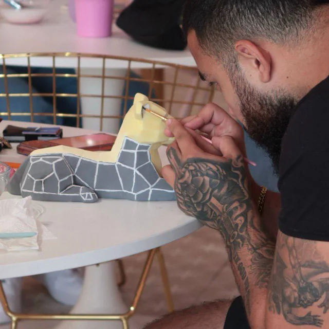 Guest painting a geometric sphinx figure