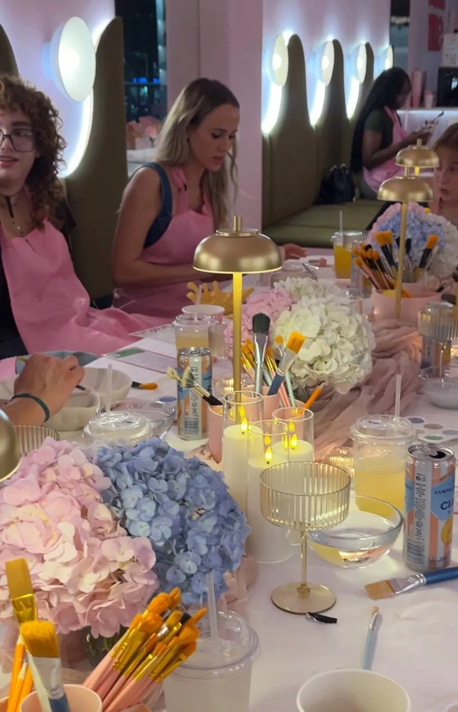 Guests painting at a candlelit decorated table