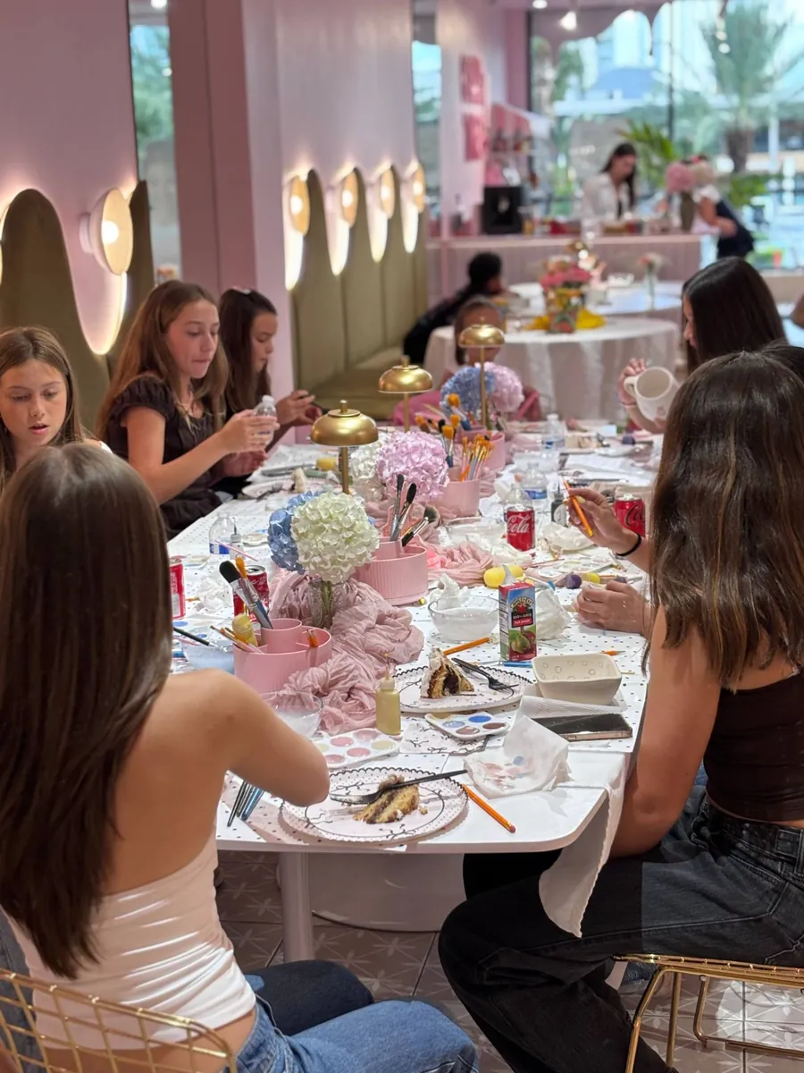 Teens painting at a long decorated party table